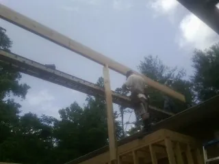 Carpenter setting a ridge beam over a new addition frame — Ice Dam Removal by Roofing Brothers in Milford Center