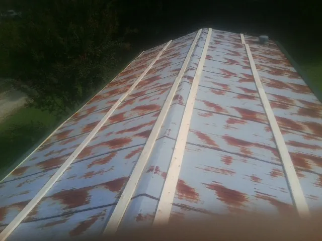 Rusted metal roof panels with new wood purlins before replacement — Storm Damage Roof Repair in Milford Center by Roofing Brothers