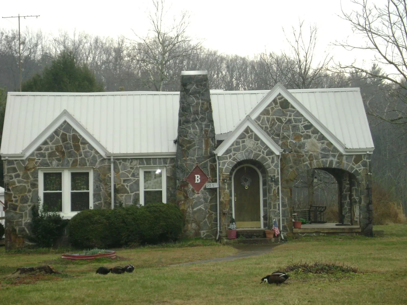 White metal roof on a stone cottage with steep gables in Milford Center